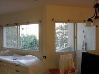 מבט מתוך הבית על חלונות גדולים בדירה בקומה שלישית אשר בבניין מגורים בעיר יהוד