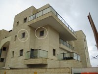 סורגית מדגם קלאסיק מותנת על חלונות קומה ראשונה בבניין מגורים בעיר אריאל.