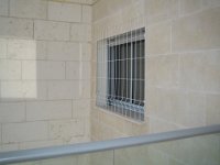 סורגית - מבט מבחוץ  הפטנט שבו סורגית מתלבשת על החלון מבחוץ ויותר גדולה ממנו ורק התפסים מתכווננים למידת החלון, הופכים את הסורגית למוצר מדף מודולרי מנצח. בתמונה ניתן לראות שהסורגית מעט בולטת ממידות החלון והחלק הנותר יושב על הקיר החיצוני. בזכות העובדה שהסורגית בעלת מראה עדין לא רואים את השארית על הקיר החיצוני של הבניין.