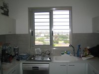 סורגית מדגם פרימיום אופקי מותקנת על החלון במטבח. חלון המטבח הוא אחד החלונות המסוכנים בדירה  ניתן לשים לב בתמונה שהמרחק בין השיש, עליו ילד עלול לשבת, לבין סף החלון הוא קטן ביותר. עובדה זו הופכת את חלון המטבח לחלון המסוכן ביותר בדירה. : סורגים, סורגים לילדים, סורג, סורגית